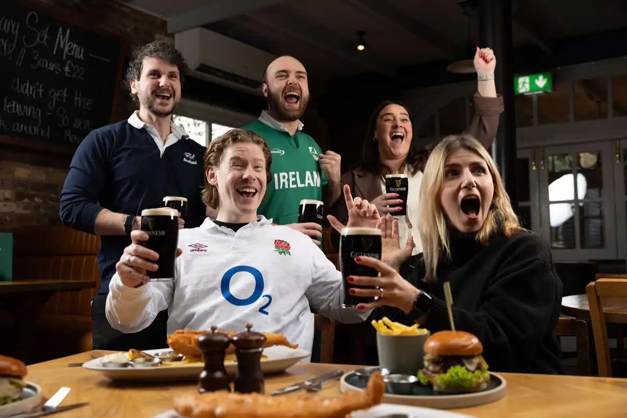 Rugby and football fans cheering in a pub